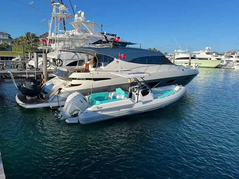Slide: The Image of 2025 Ranieri CAYMAN 27.0 SPORT TOURING docked beside a luxury yacht in a marina. - 3