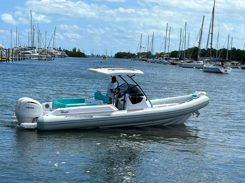The Image of 2025 Ranieri CAYMAN 27.0 SPORT TOURING boat cruising in a marina with sailboats. - 0