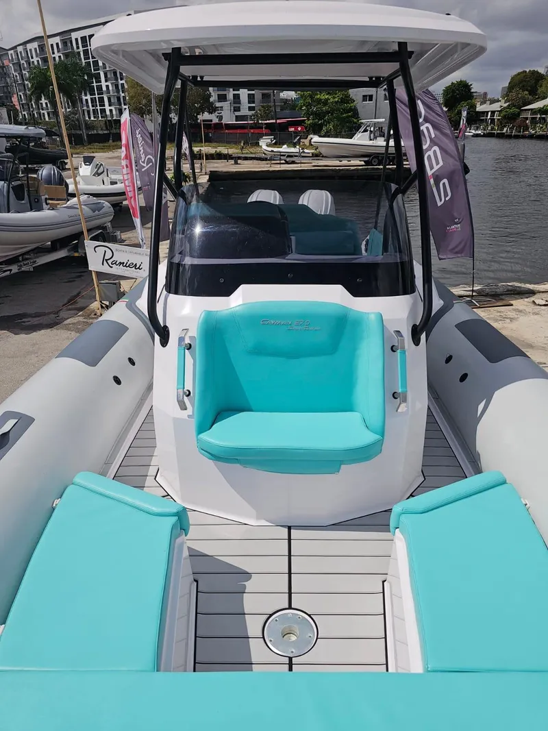 Slide: The Image of 2025 Ranieri CAYMAN 27.0 SPORT TOURING boat with turquoise seating docked by the water. - 22