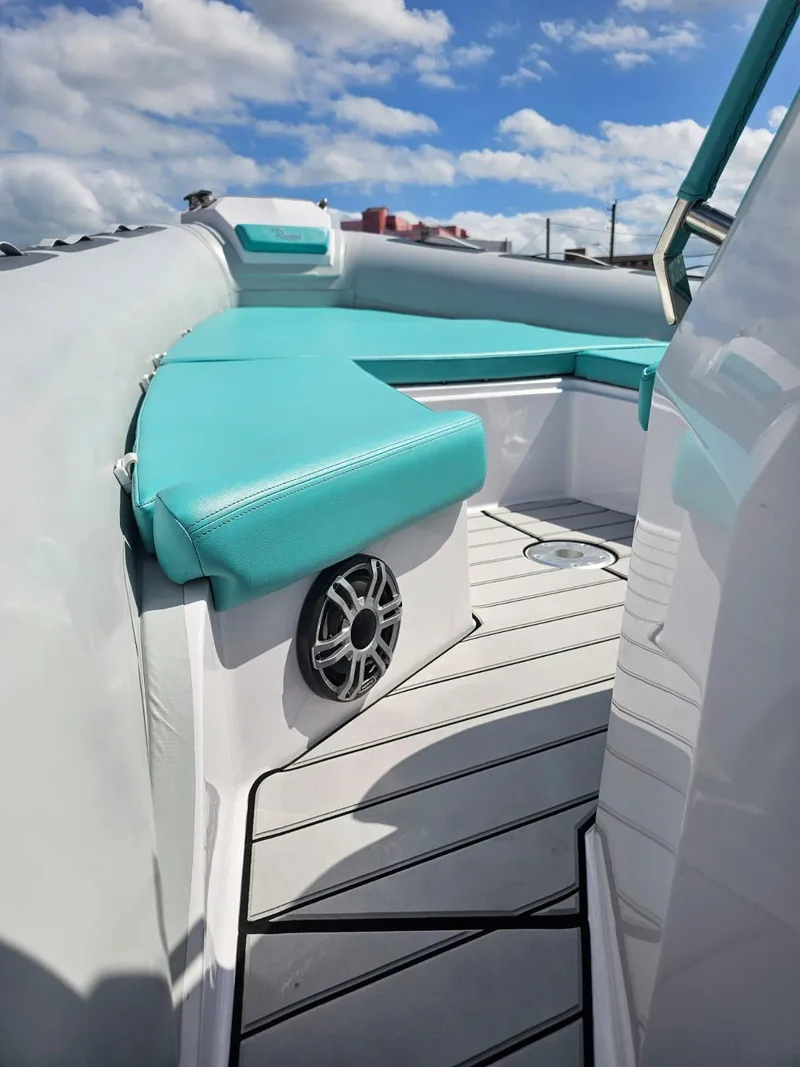 Slide: The Image of 2025 Ranieri CAYMAN 27.0 SPORT TOURING boat interior with teal seating and speaker. - 24