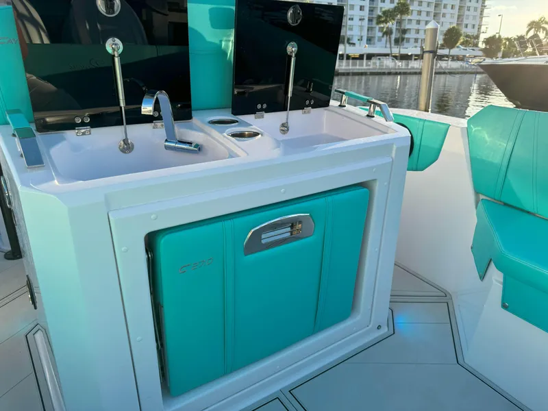 Slide: The Image of 2025 Ranieri Cayman 27.0 Sport Touring boat interior with dual sinks and turquoise accents. - 33