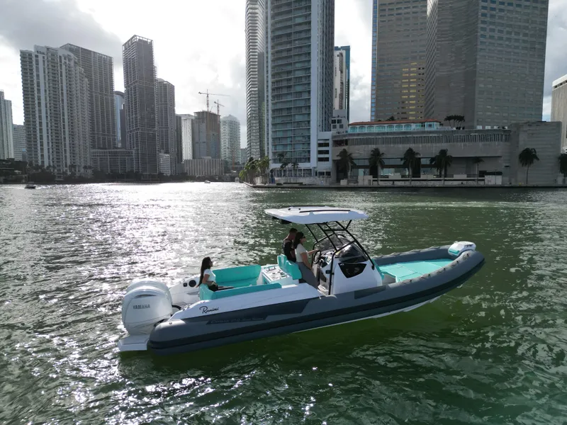 Slide: The Image of 2025 Ranieri CAYMAN 27.0 SPORT TOURING boat cruising in urban waterfront setting. - 5