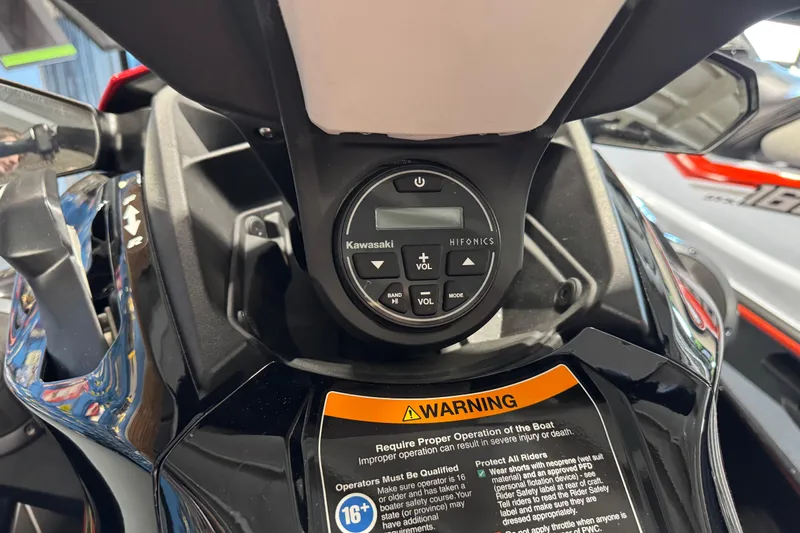 Slide: The Image of 2025 Kawasaki STX160LX dashboard with Hifonics audio controls and warning label. - 7