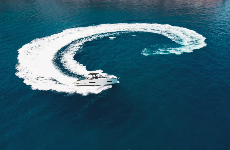 Slide: The Image of 2024 De Antonio Yachts D50 OPEN making a circular wake in blue ocean waters. - 11
