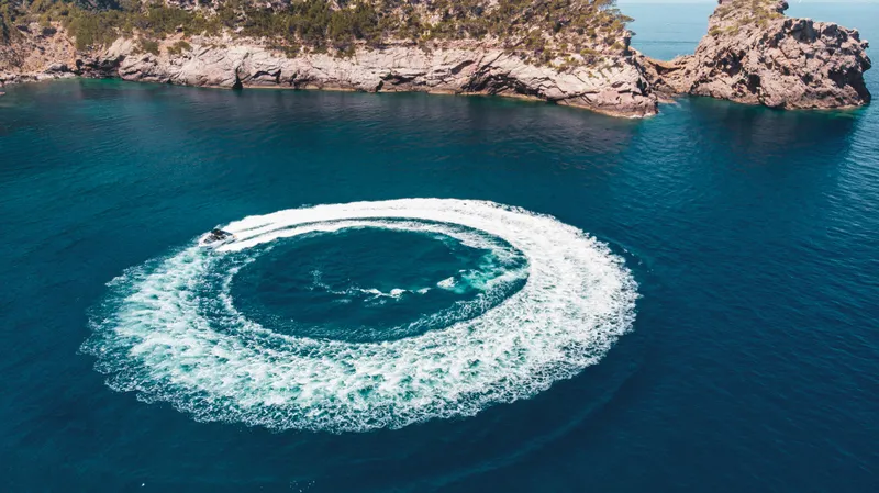 Slide: The Image of Aerial view of De Antonio Yachts D50 OPEN creating circular wake in blue sea, 2024 model. - 12