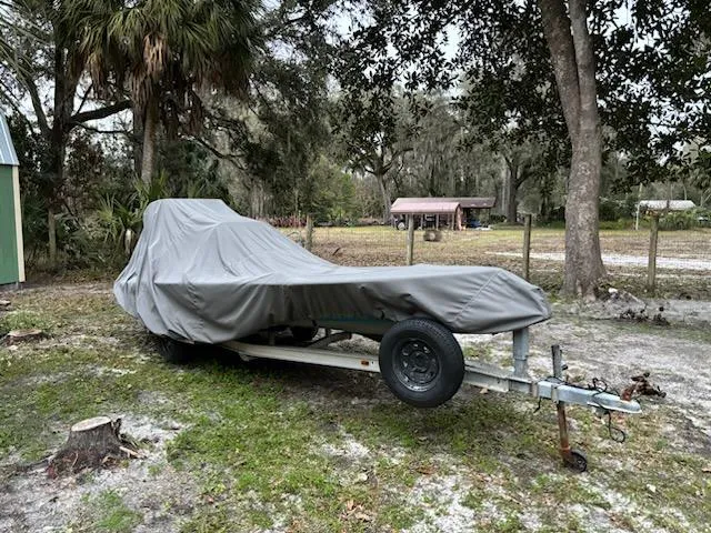 Slide: The Image of Covered 2009 Hell's Bay WATERMAN boat on trailer in wooded area. - 10