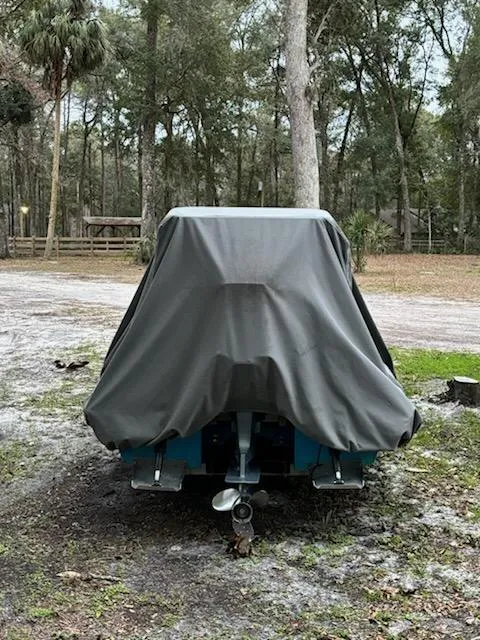 Slide: The Image of 2009 Hell's Bay WATERMAN boat covered, parked in a wooded area. - 11