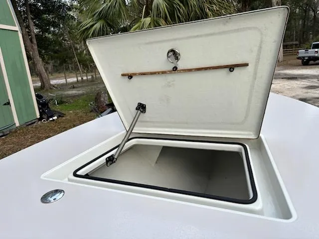 Slide: The Image of Open storage compartment on 2009 Hell's Bay WATERMAN boat, surrounded by trees and a shed. - 6