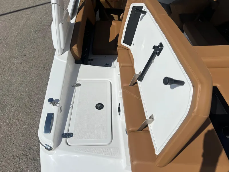 Slide: The Image of 2023 Four Winns H4 boat interior with tan and white seating and storage compartments. - 10