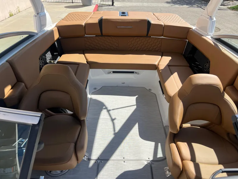 Slide: The Image of 2023 Four Winns H4 boat interior with tan leather seating and spacious layout. - 18