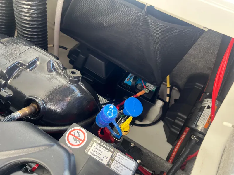 Slide: The Image of 2023 Four Winns H4 engine compartment with battery and wiring components. - 25