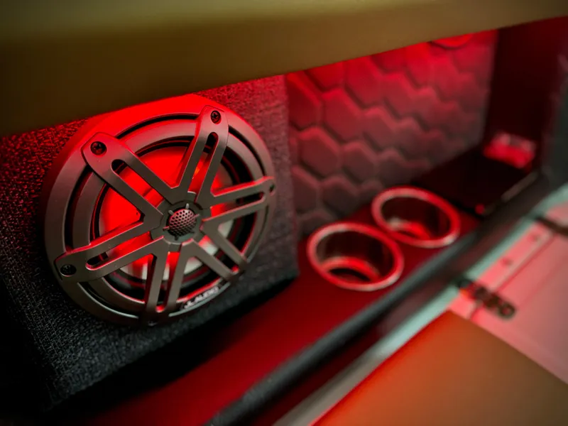 Slide: The Image of 2023 Four Winns H4 boat interior with red-lit speaker and cup holders. - 36