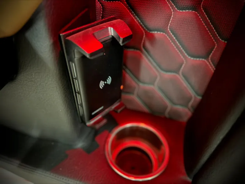 Slide: The Image of 2023 Four Winns H4 interior with wireless charging and cup holder, red accent lighting. - 40
