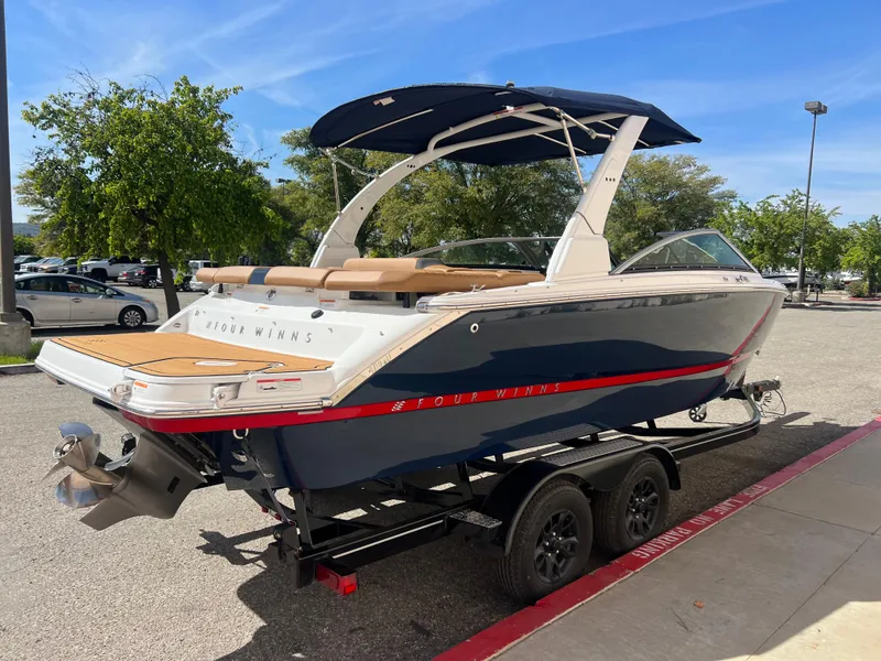 Slide: The Image of 2023 Four Winns H4 boat on a trailer with a blue and white exterior. - 5