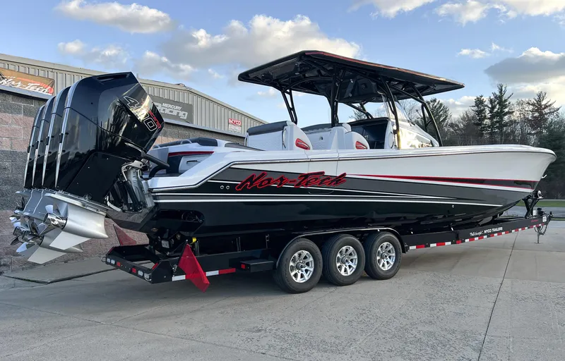 Slide: The Image of 2025 Nor-Tech 390 Sport boat on trailer, sleek design, powerful engines, outdoor setting. - 2