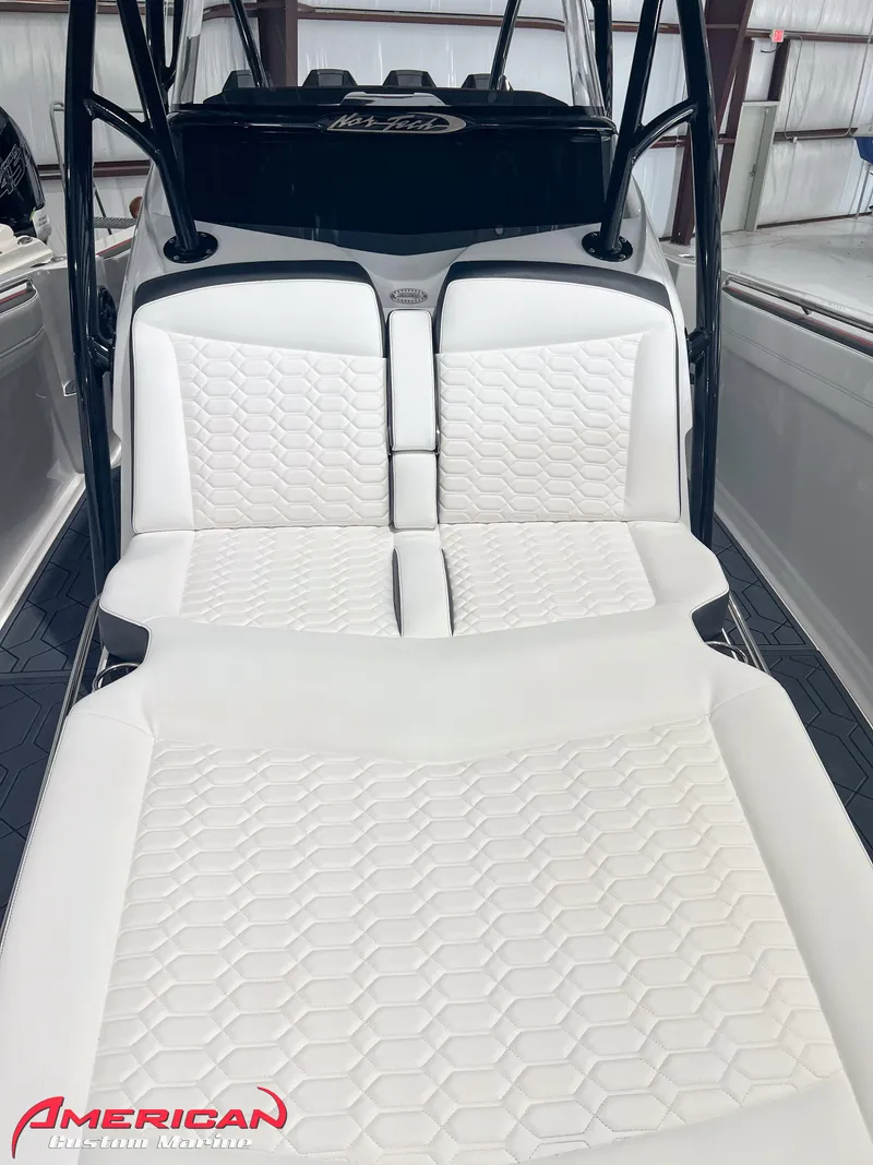 Slide: The Image of 2025 Nor-Tech 390 Sport boat with luxurious white seating in a showroom. - 31