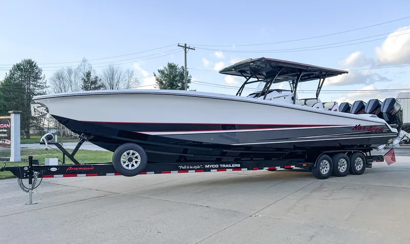 Slide: The Image of 2025 Nor-Tech 390 Sport boat on trailer, sleek design, triple engines, outdoor setting. - 4