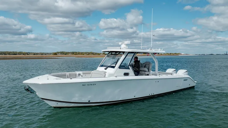 Slide: The Image of 2022 Pursuit S 328 boat cruising on a calm sea under a partly cloudy sky. - 2