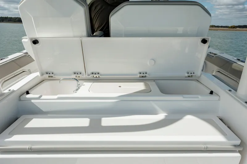 Slide: The Image of 2022 Pursuit S 328 boat with open storage compartments on deck. - 33