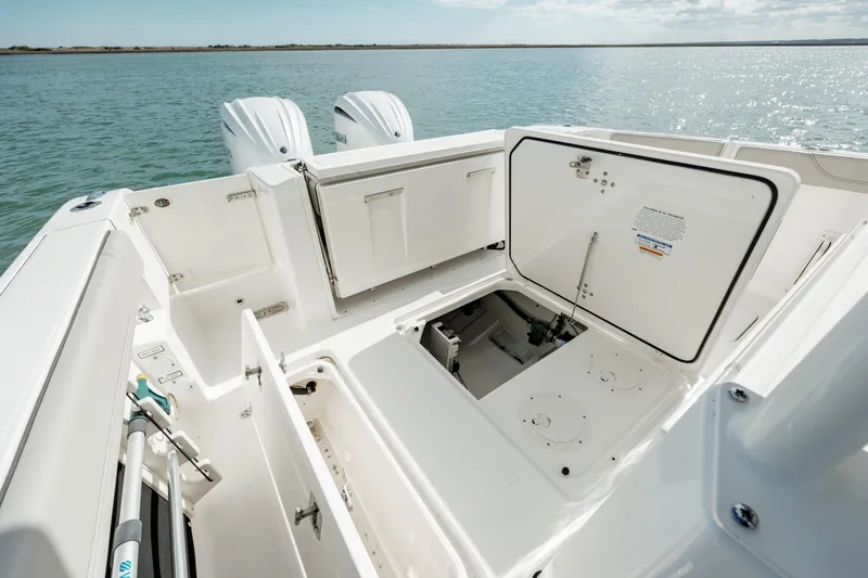 Slide: The Image of 2022 Pursuit S 328 boat with open storage compartments and twin engines. - 34