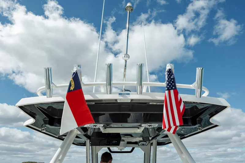 Slide: The Image of 2022 Pursuit S 328 boat with flags against a blue sky. - 35