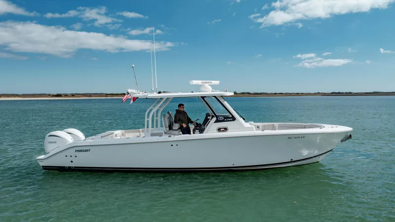 Slide: The Image of 2022 Pursuit S 328 boat cruising on clear blue water under a sunny sky. - 5