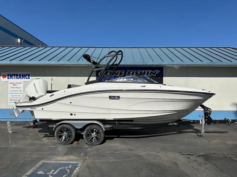 Slide: The Image of 2024 Sea Ray SPX 210 OB boat on trailer, parked outside a building. - 0