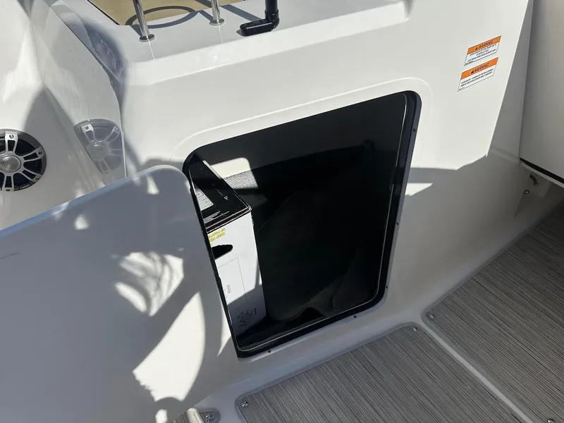 Slide: The Image of 2024 Sea Ray SPX 210 OB boat storage compartment with open hatch. - 17