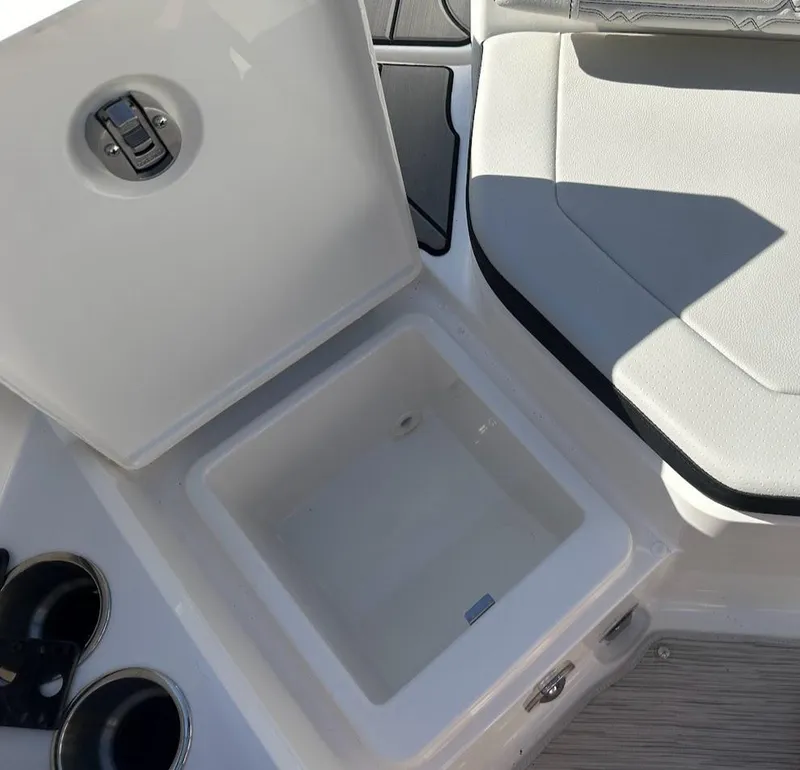 Slide: The Image of 2024 Sea Ray SPX 210 OB boat interior with open storage compartment and seating. - 18