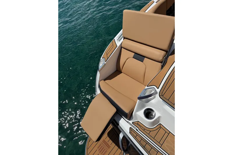 Slide: The Image of 2024 MasterCraft X26 boat with tan seating and teak flooring on clear water. - 15