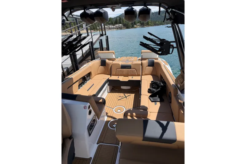 Slide: The Image of 2024 MasterCraft X26 boat interior with tan seating and lake view. - 8