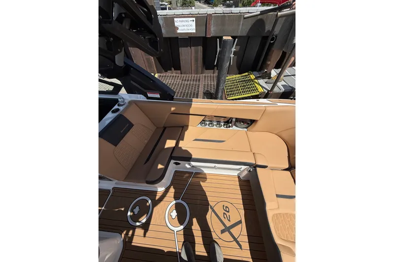 Slide: The Image of 2024 MasterCraft X26 boat interior with tan seating and teak flooring. - 11