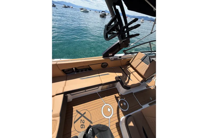 Slide: The Image of 2024 MasterCraft X26 boat interior with tan seating and lake view. - 10