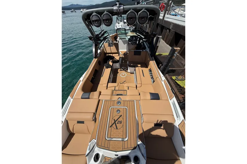 Slide: The Image of 2024 MasterCraft X26 boat interior with tan seating and advanced audio system. - 6