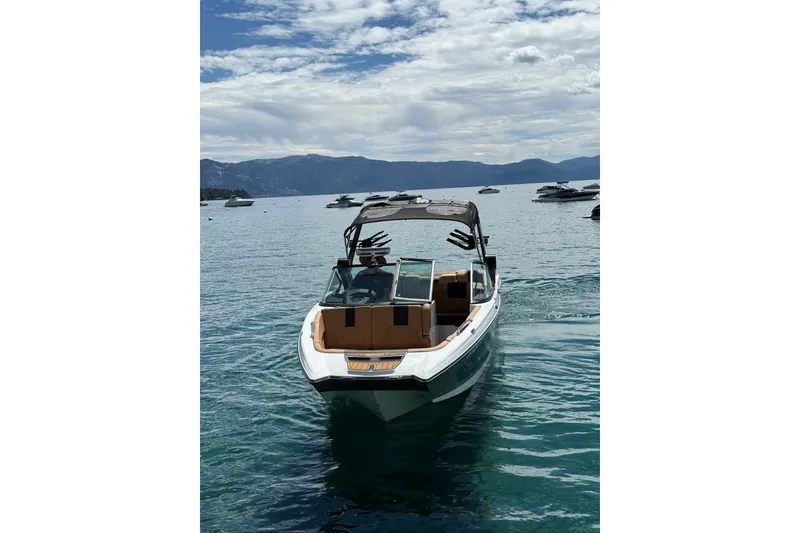 Slide: The Image of 2024 MasterCraft X26 boat on a serene lake with mountains in the background. - 5