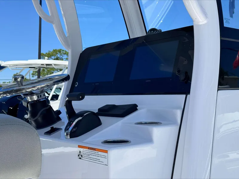 Slide: The Image of 2024 Sportsman 267 Masters OE boat dashboard with steering wheel and dual screens. - 8