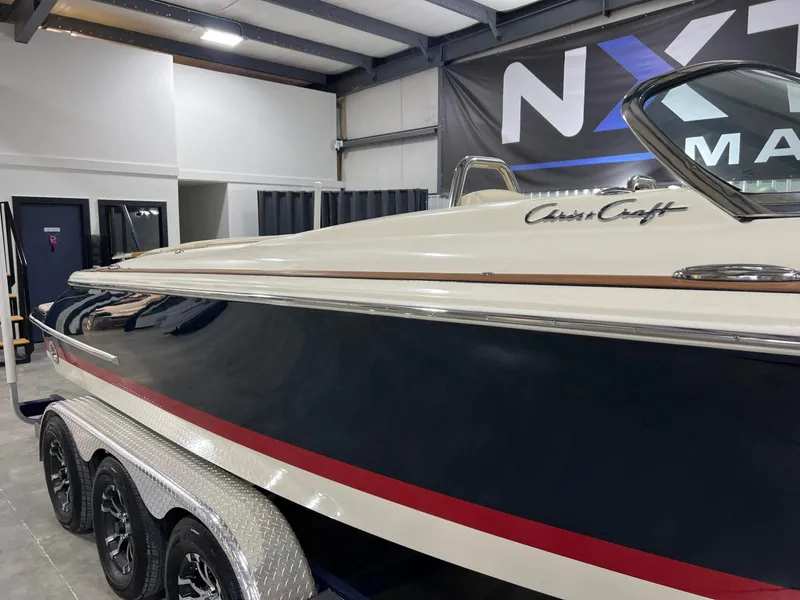 Slide: The Image of 2023 Chris-Craft Launch 27 boat in showroom, side view with trailer. - 13