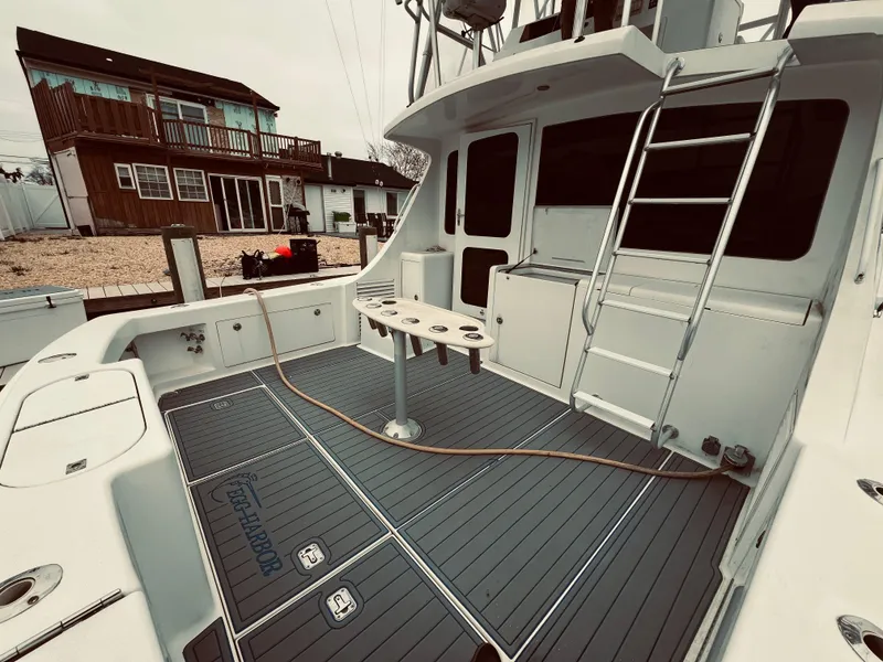 Slide: The Image of 2002 Egg Harbor 42 Sport Fish boat deck with fishing rod holders and ladder. - 12