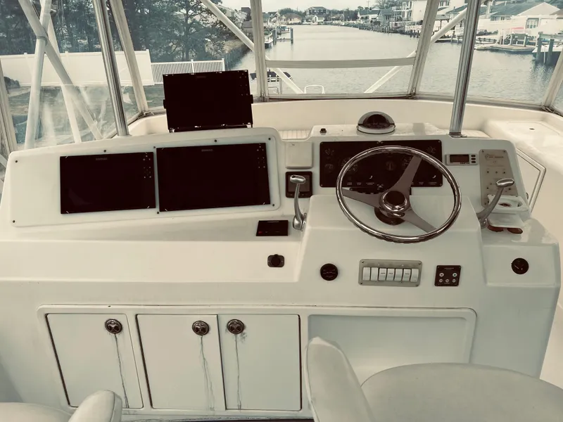 Slide: The Image of 2002 Egg Harbor 42 Sport Fish boat helm with navigation screens and steering wheel. - 13