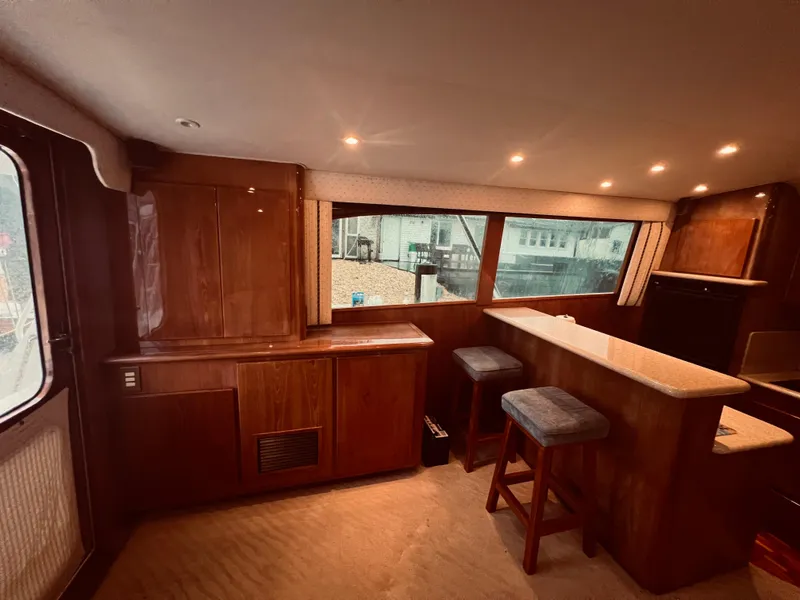 Slide: The Image of Interior of 2002 Egg Harbor 42 Sport Fish yacht with wooden cabinetry and bar stools. - 22
