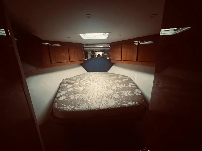 Slide: The Image of 2002 Egg Harbor 42 Sport Fish cabin interior with bed and wooden cabinets. - 24