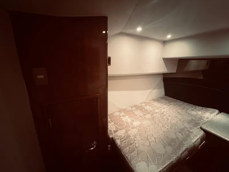 Slide: The Image of Interior cabin of a 2002 Egg Harbor 42 Sport Fish boat with bed and wooden door. - 25