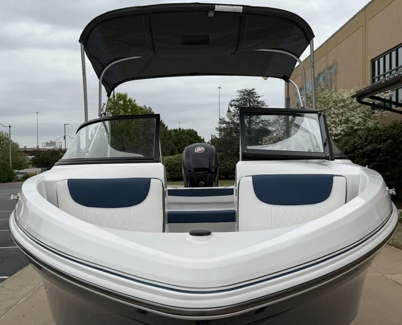 Slide: The Image of 2023 Tahoe 185 S boat with canopy, front view, parked outdoors. - 7
