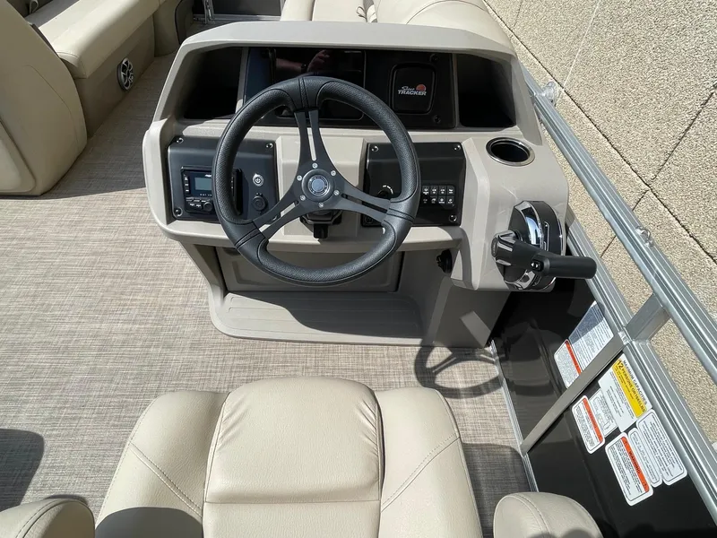 Slide: The Image of 2024 Sun Tracker Party Barge 24 DLX helm with steering wheel and controls. - 4