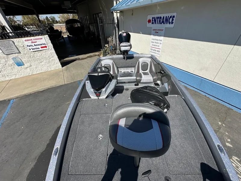 Slide: The Image of 2024 Ranger Z519 boat interior with seating and controls, parked near a building entrance. - 20