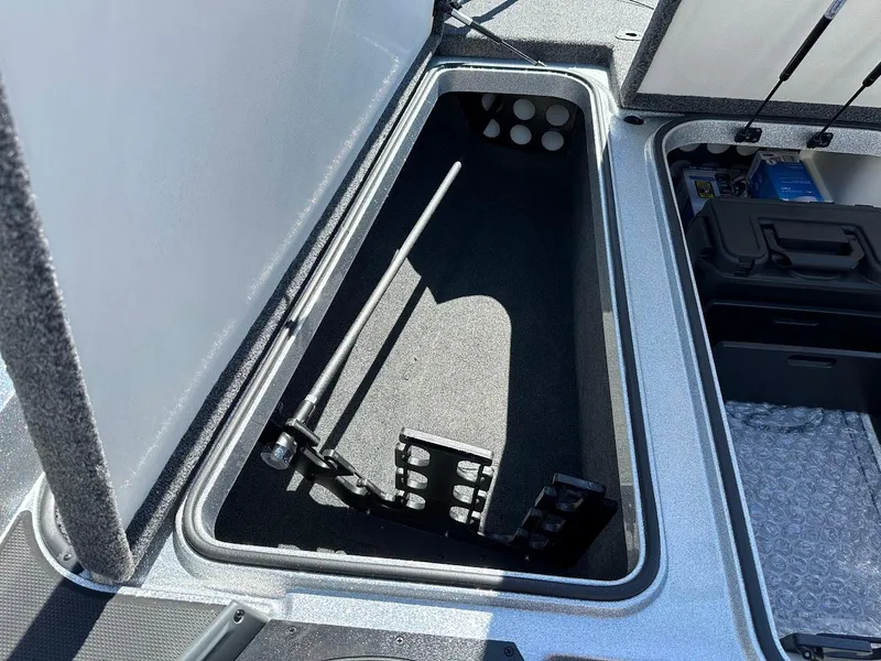 Slide: The Image of 2024 Ranger Z519 boat storage compartment with rod holders and organized interior. - 24