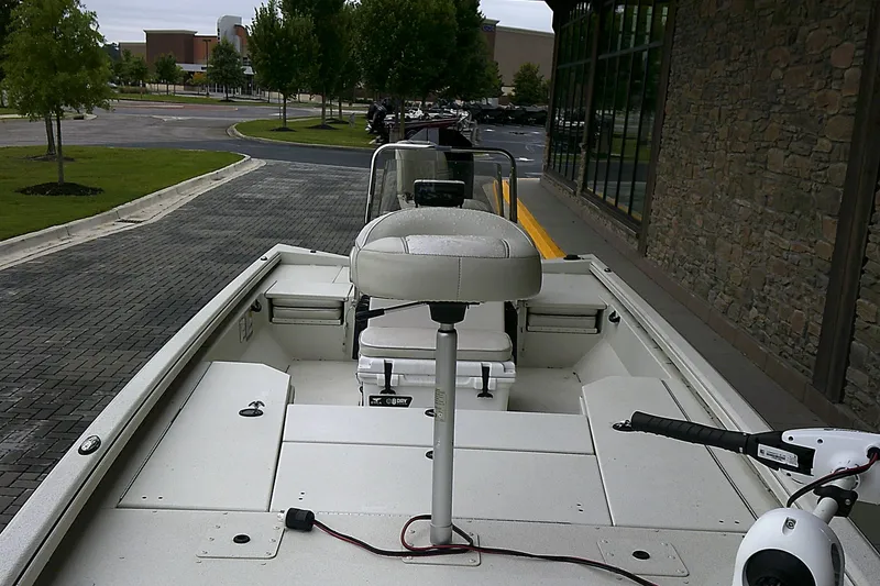Slide: The Image of 2024 Ranger RB210 boat with seating, parked on a paved area near a building. - 4