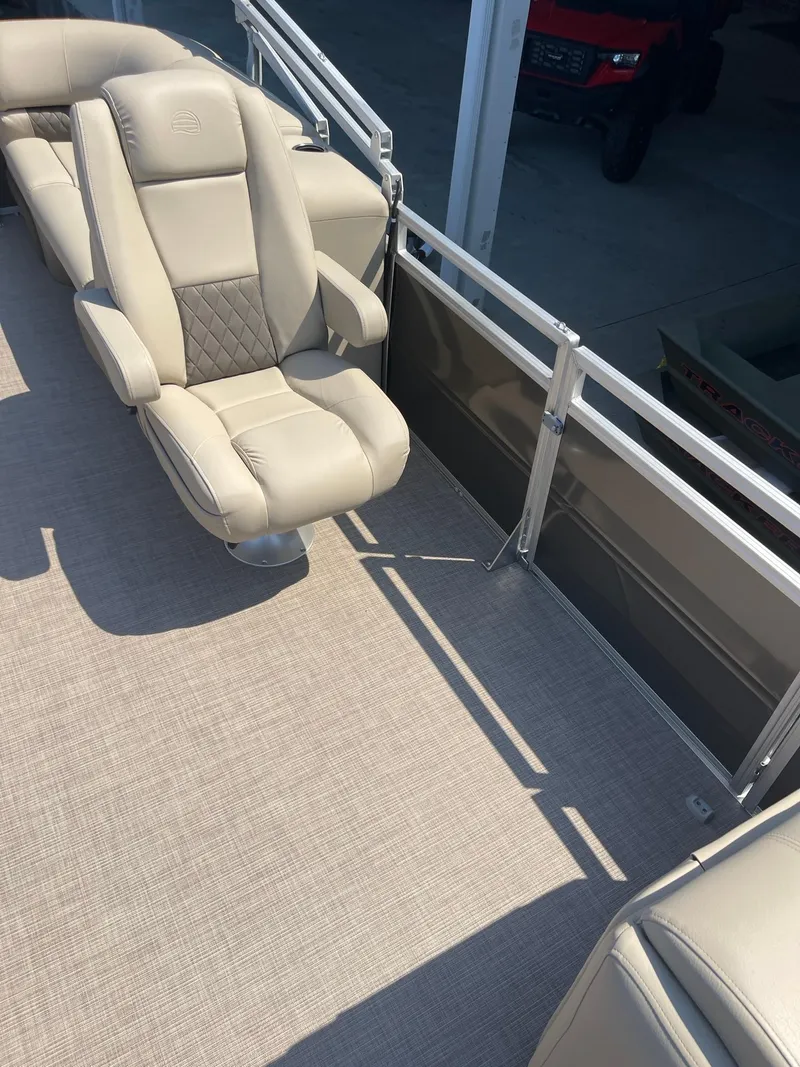 Slide: The Image of 2024 Sun Tracker Party Barge 24 DLX interior with beige seating and carpet. - 5