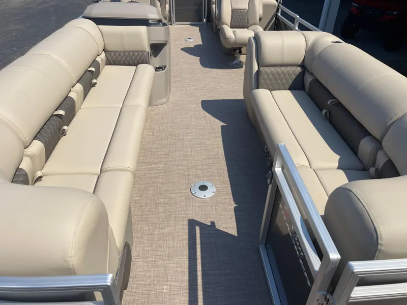 Slide: The Image of 2024 Sun Tracker Party Barge 24 DLX interior with beige seating and spacious layout. - 6