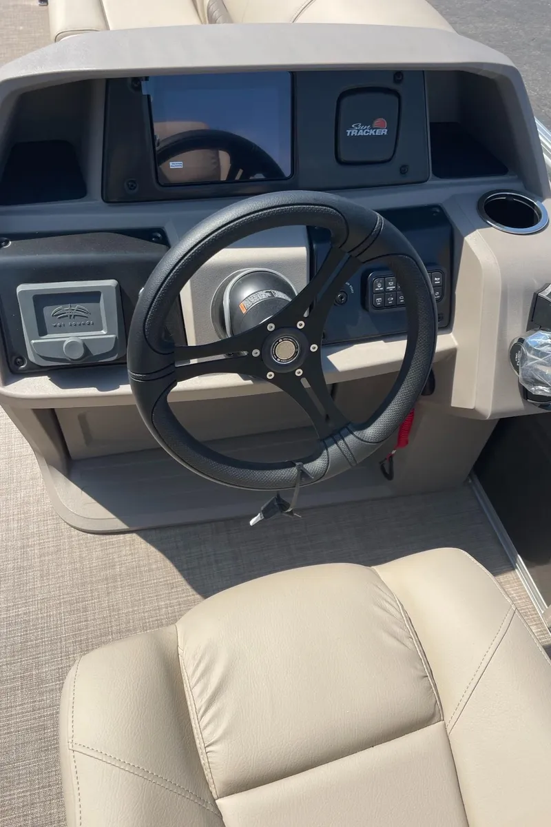 Slide: The Image of 2024 Sun Tracker Party Barge 24 DLX steering console with modern controls and comfortable seating. - 9